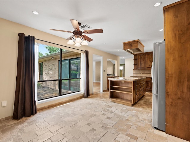 kitchen with a ceiling fan, visible vents, open shelves, freestanding refrigerator, and stone tile floors