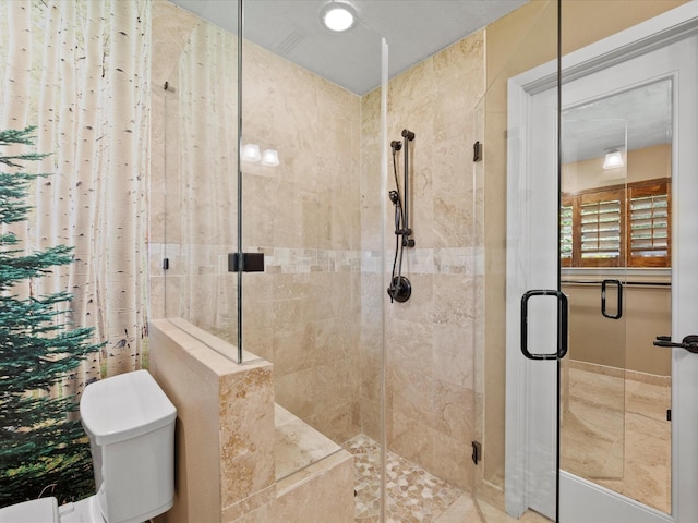bathroom featuring a stall shower and toilet
