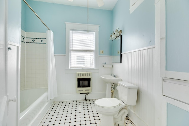 full bath featuring heating unit, a wainscoted wall, toilet, ceiling fan, and shower / tub combo