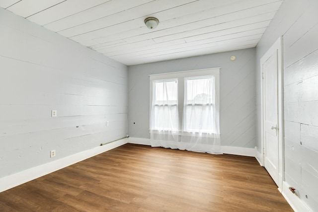 spare room featuring wood finished floors and baseboards