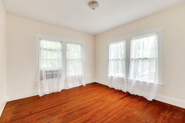 empty room featuring hardwood / wood-style floors and baseboards
