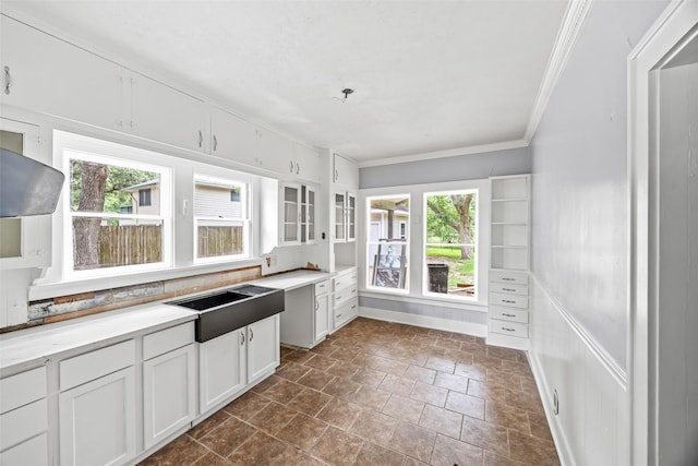 212 W Alabama St, Wharton, TX 77488 - kitchen featuring crown molding, white cabinets, glass insert cabinets, light countertops, and dark stone finish floors