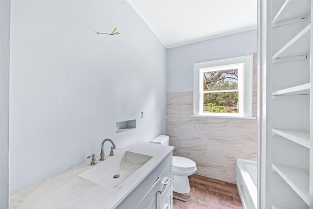 212 W Alabama St, Wharton, TX 77488 - bathroom featuring vanity, a bathtub, ornamental molding, and wood finished floors