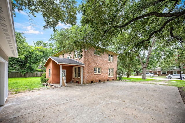 212 W Alabama St, Wharton, TX 77488 - back of property featuring driveway, brick siding, and a patio area