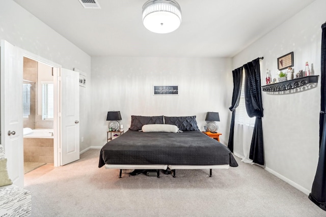 carpeted bedroom featuring baseboards, visible vents, and ensuite bath
