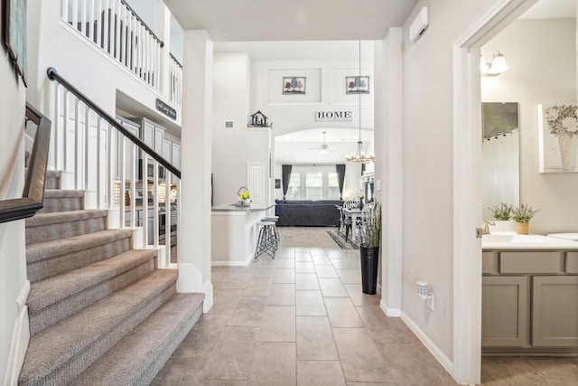 foyer entrance featuring light tile patterned floors, a ceiling fan, baseboards, and stairway