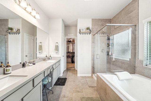 full bathroom featuring a bath, double vanity, a sink, and a shower stall