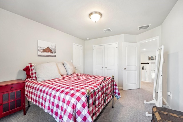 carpeted bedroom featuring visible vents and a closet