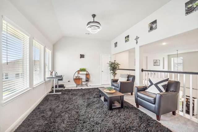 living area featuring baseboards, a wealth of natural light, carpet flooring, and vaulted ceiling