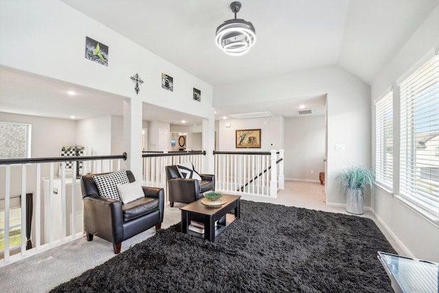 living area featuring carpet, an upstairs landing, baseboards, visible vents, and lofted ceiling