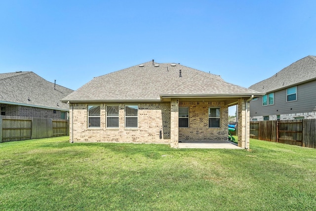 back of house with a lawn, a fenced backyard, brick siding, and a patio
