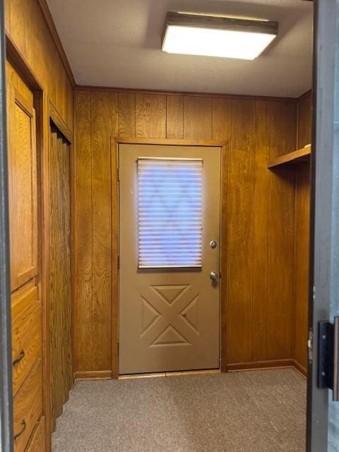 entryway with wood walls and carpet floors