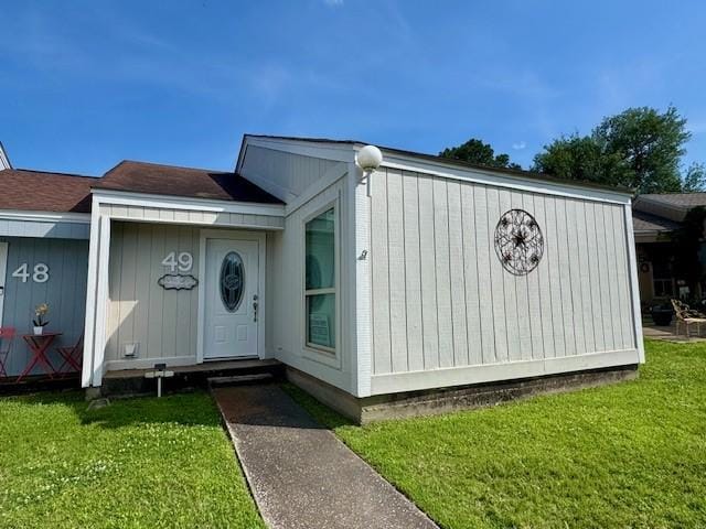 entrance to property with a lawn