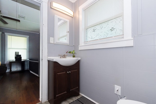 half bathroom featuring visible vents, wood finished floors, ceiling fan, and vanity