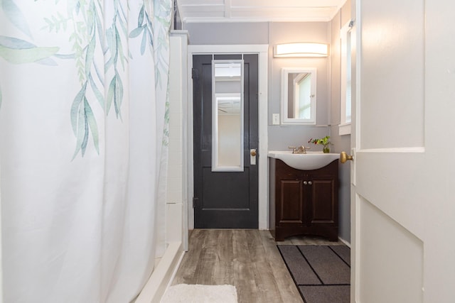 interior space featuring vanity, wood finished floors, and a shower with shower curtain