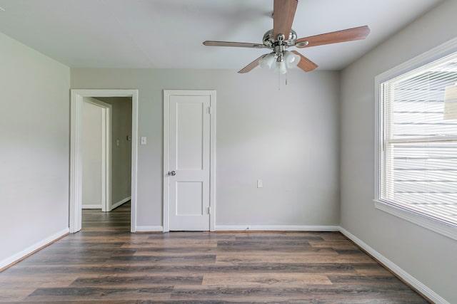 unfurnished room featuring a ceiling fan, dark wood-style flooring, and a wealth of natural light