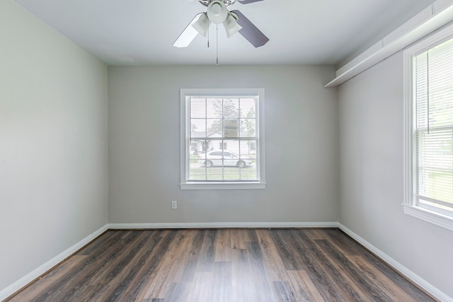 spare room with baseboards, a ceiling fan, and dark wood-style flooring