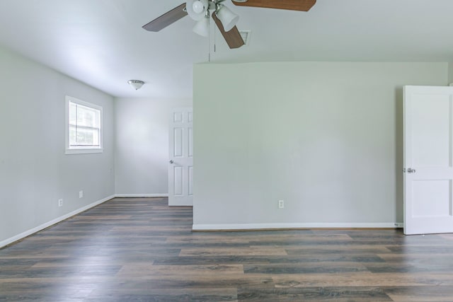 spare room featuring baseboards, a ceiling fan, and dark wood-style floors