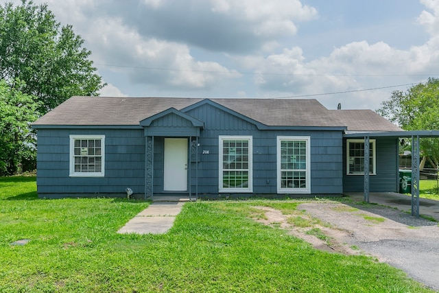 ranch-style home with a front lawn and roof with shingles