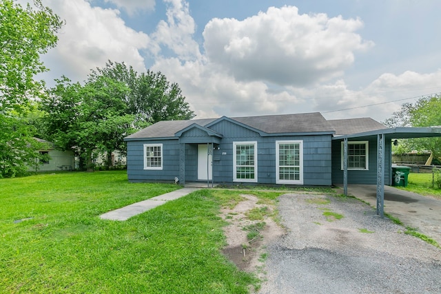 ranch-style house with a front lawn, a shingled roof, driveway, a carport, and fence
