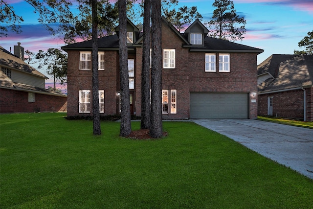 view of front of home with a front yard, concrete driveway, a garage, and brick siding