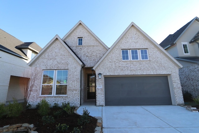 view of front of house with driveway, a garage, and brick siding