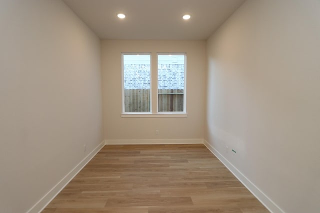 spare room with light wood-type flooring, recessed lighting, and baseboards