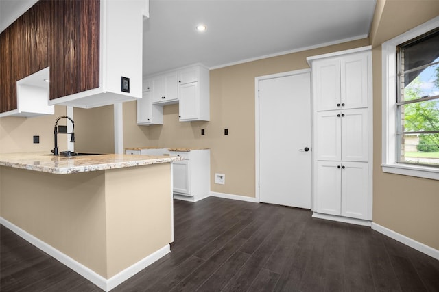 106 Rosewood Dr, Crockett, TX 75835 - kitchen featuring dark wood finished floors, white cabinetry, light stone counters, baseboards, and a peninsula