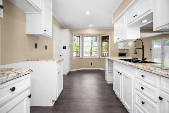 106 Rosewood Dr, Crockett, TX 75835 - kitchen featuring light stone counters, white cabinetry, a sink, baseboards, and recessed lighting