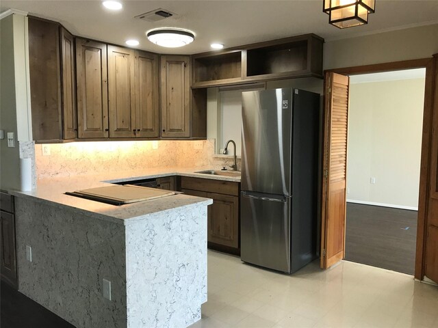 104 Bayside St, Livingston, TX 77351 - kitchen featuring tasteful backsplash, open shelves, a sink, visible vents, and freestanding refrigerator