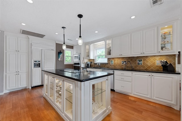 kitchen with stainless steel appliances, dark countertops, visible vents, and white cabinetry
