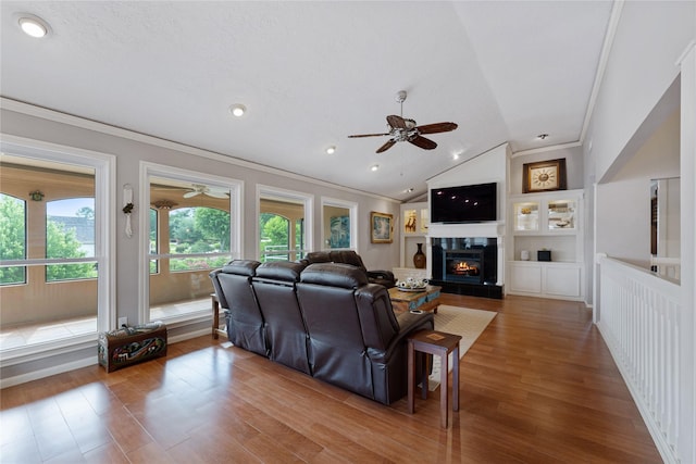 living room featuring ceiling fan, ornamental molding, and lofted ceiling