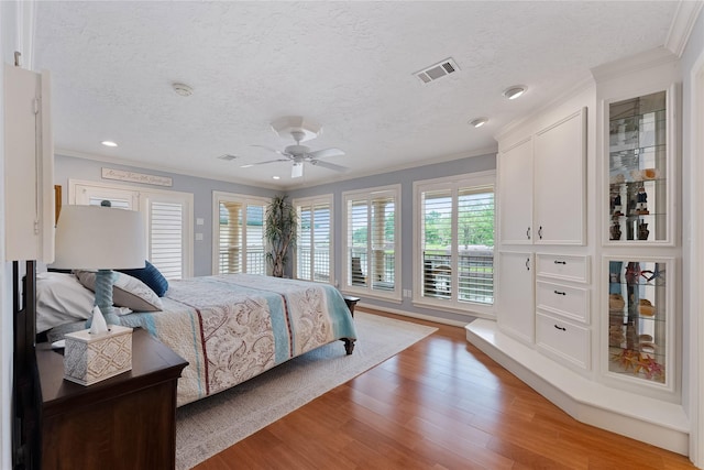 bedroom with visible vents, ornamental molding, and multiple windows
