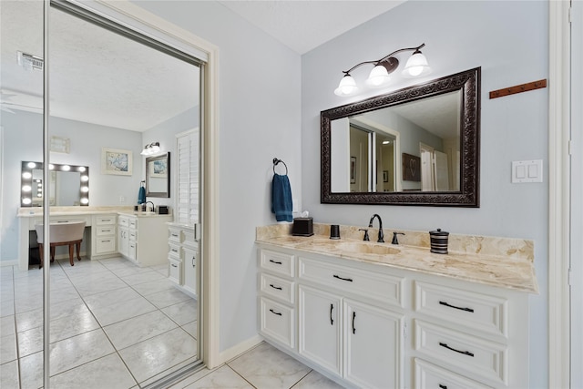 bathroom with baseboards, marble finish floor, and vanity