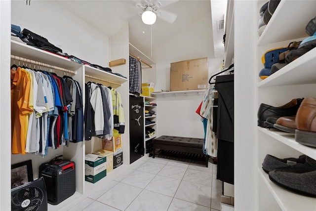 spacious closet featuring visible vents, ceiling fan, light tile patterned floors, and vaulted ceiling