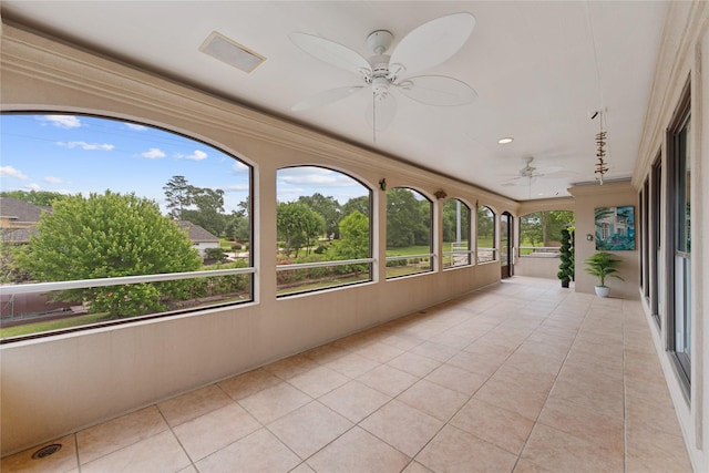 unfurnished sunroom featuring tile patterned flooring, a ceiling fan, recessed lighting, and visible vents