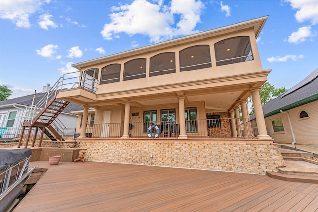 back of house featuring stairs, a wooden deck, and stucco siding