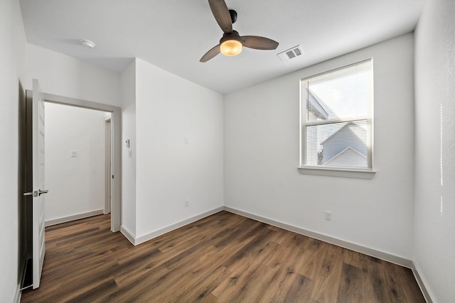 spare room with wood finished floors, visible vents, ceiling fan, and baseboards