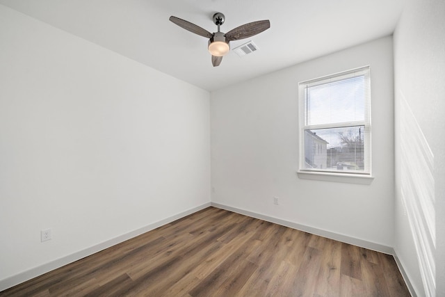 unfurnished room featuring wood finished floors, ceiling fan, visible vents, and baseboards
