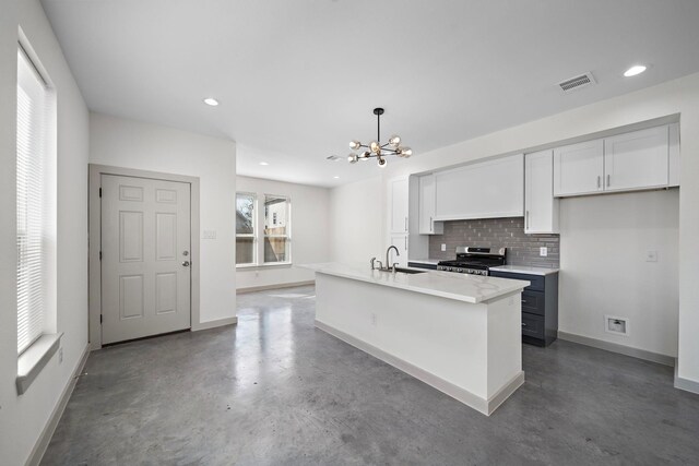 kitchen with a sink, a chandelier, decorative backsplash, visible vents, and gas range