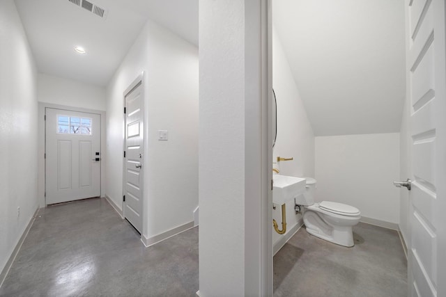bathroom with finished concrete flooring, visible vents, toilet, and baseboards