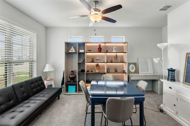 recreation room with light colored carpet, visible vents, and a ceiling fan