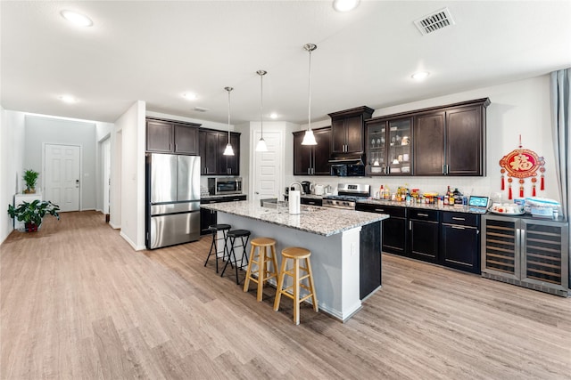 kitchen featuring visible vents, appliances with stainless steel finishes, light wood finished floors, and wine cooler