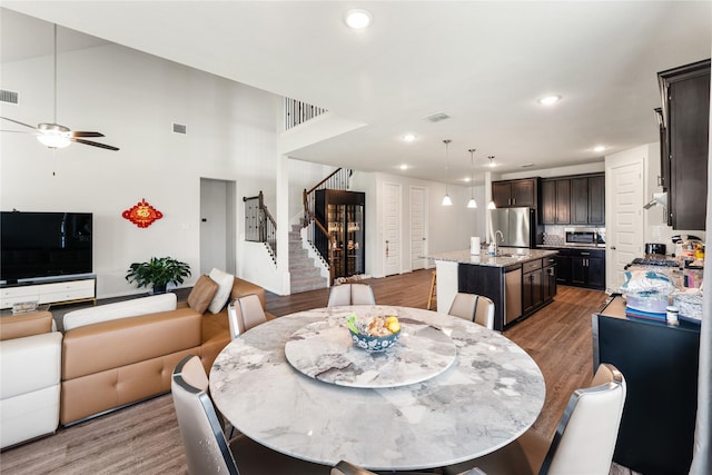 dining space featuring recessed lighting, wood finished floors, stairway, ceiling fan, and visible vents