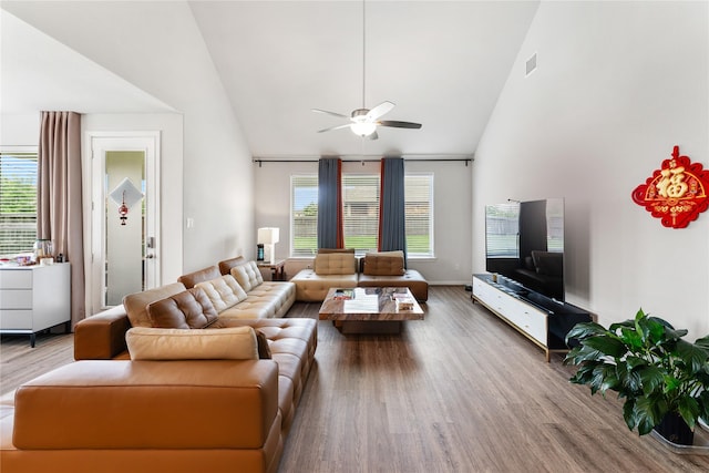 living room with high vaulted ceiling, wood finished floors, a wealth of natural light, and ceiling fan