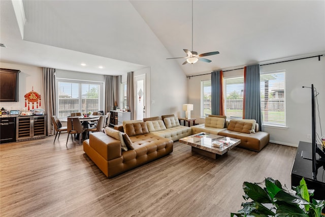 living area with high vaulted ceiling, ceiling fan, light wood finished floors, and wine cooler