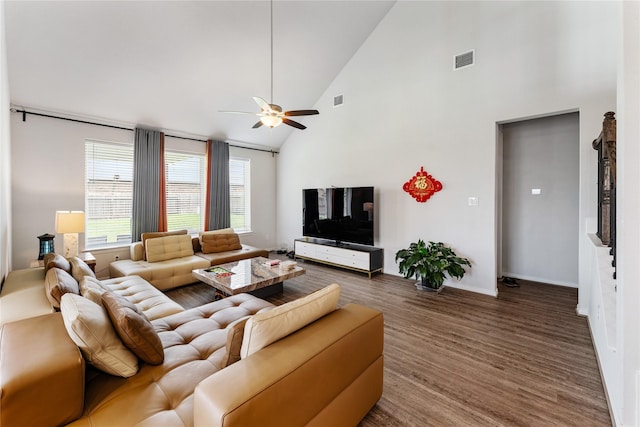 living room with high vaulted ceiling, a ceiling fan, visible vents, baseboards, and wood finished floors