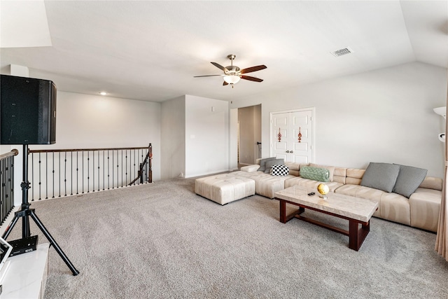 carpeted living room with ceiling fan, visible vents, and vaulted ceiling