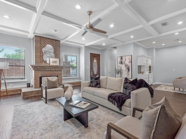living room featuring baseboards, visible vents, wood finished floors, and coffered ceiling