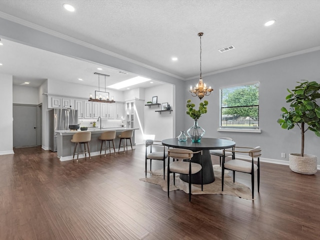 dining room with crown molding, visible vents, dark wood-style flooring, and a chandelier